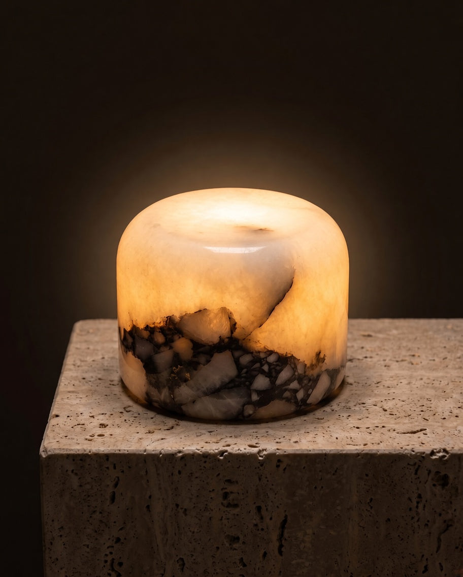 Lampe Albéa allumée sur un socle de travertin